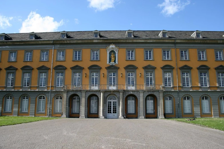 an old building with lots of windows and lots of grass