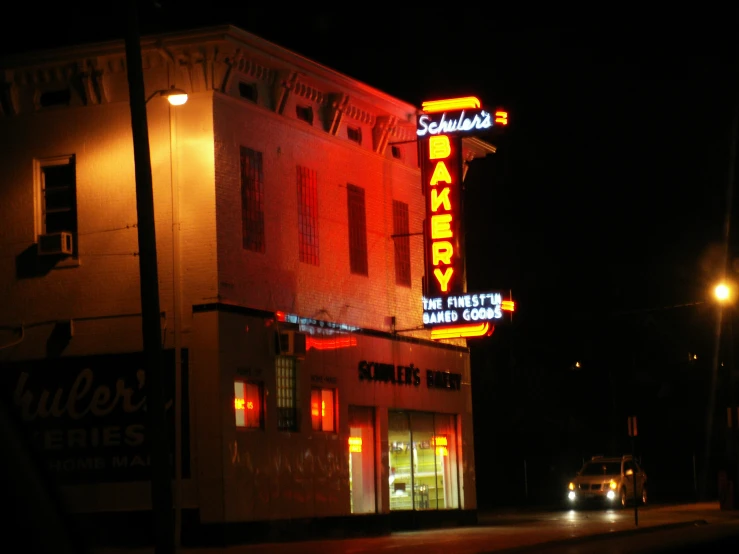 a brightly lit neon sign atop the side of a building