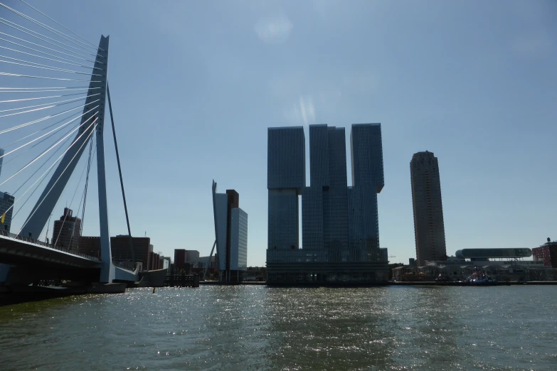 a city skyline from the water with a bridge