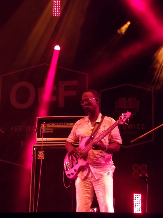 a man playing guitar on stage at a concert