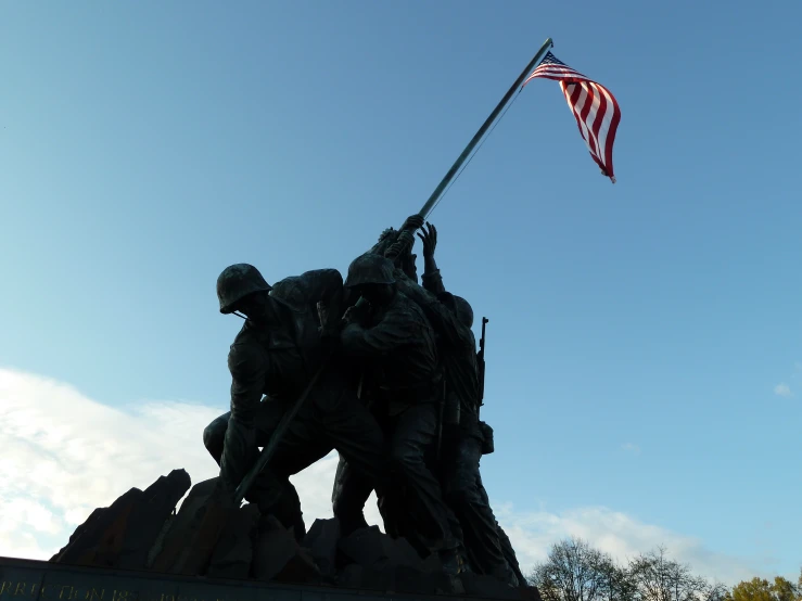 a statue with some soldiers and an american flag on top of it