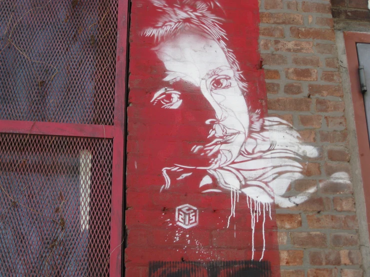 a red wall with white graffiti and the image of a man