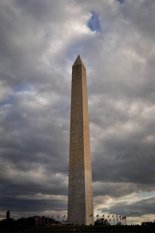 a large stone monument stands under a cloudy sky
