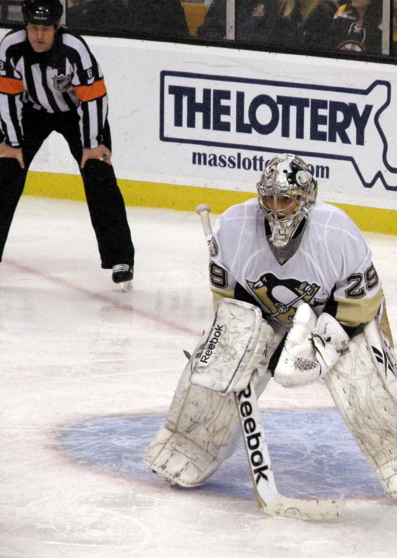 an ice hockey goaltender in white waiting to hit the puck