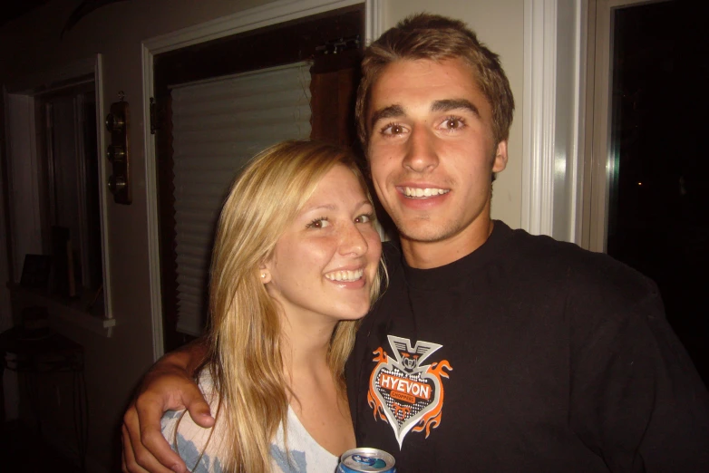 a woman and man are posing with a beer