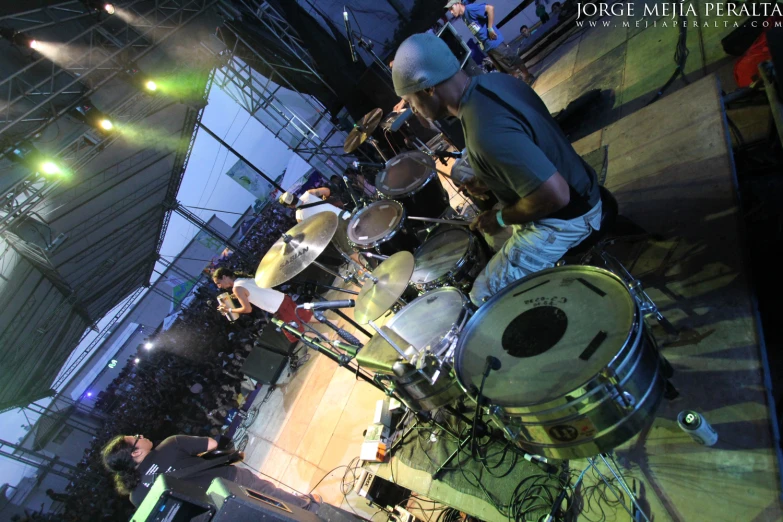 the drummer plays drums on stage at night