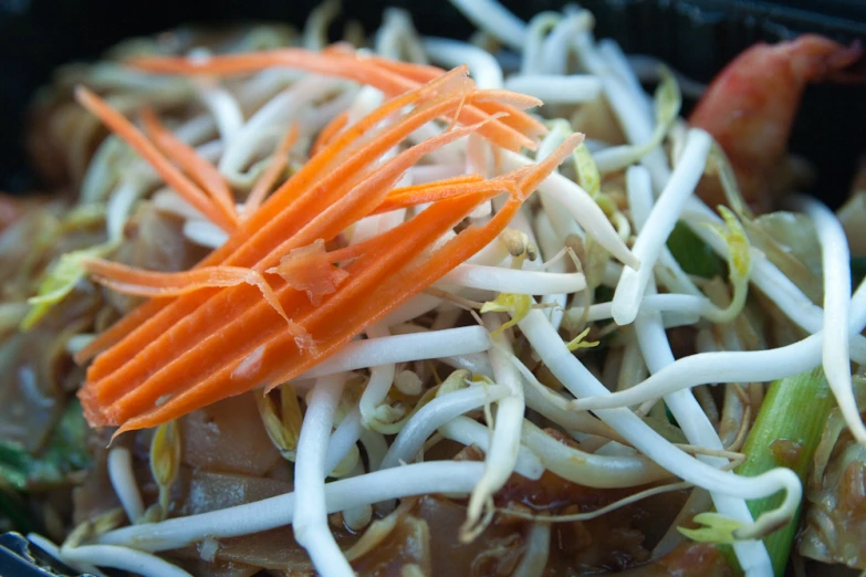 a bunch of vegetables sit in a container with noodles