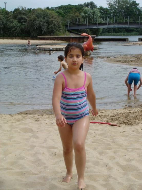 a girl in a bathing suit is standing on the beach