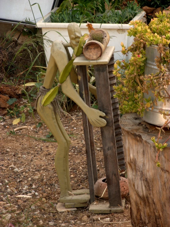 a statue in the middle of some grass and dirt