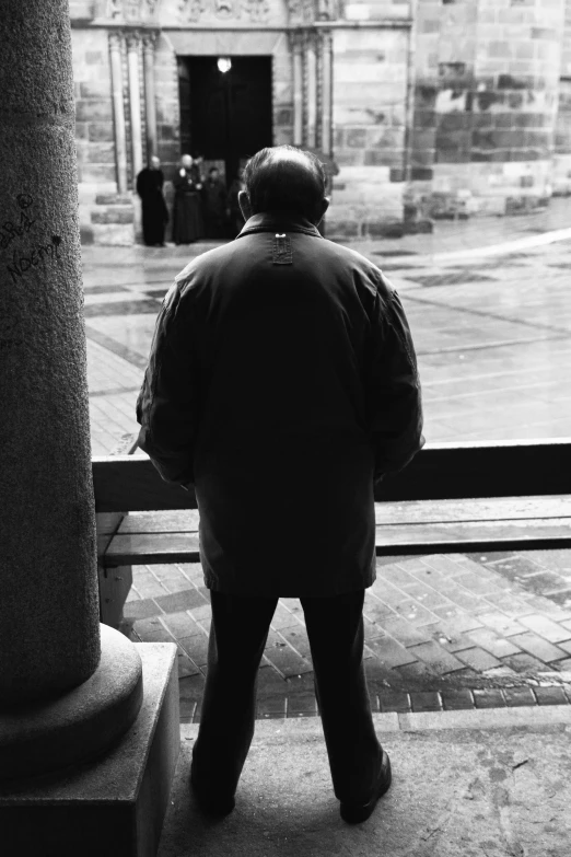 man standing and watching in front of open glass door