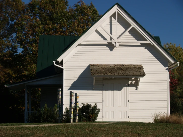 a barn with a porch on the front and white siding