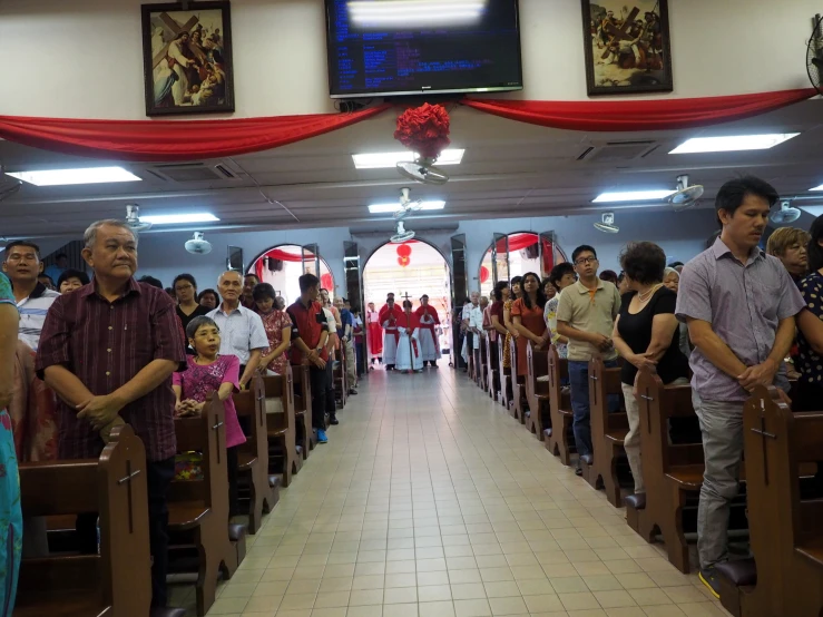 an older man wearing a shirt is standing at the end of a church