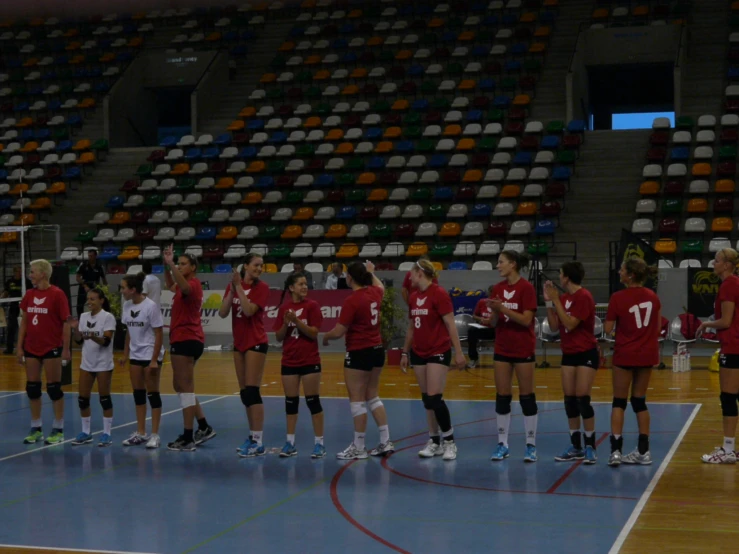 a group of girls huddle together while wearing red shirts