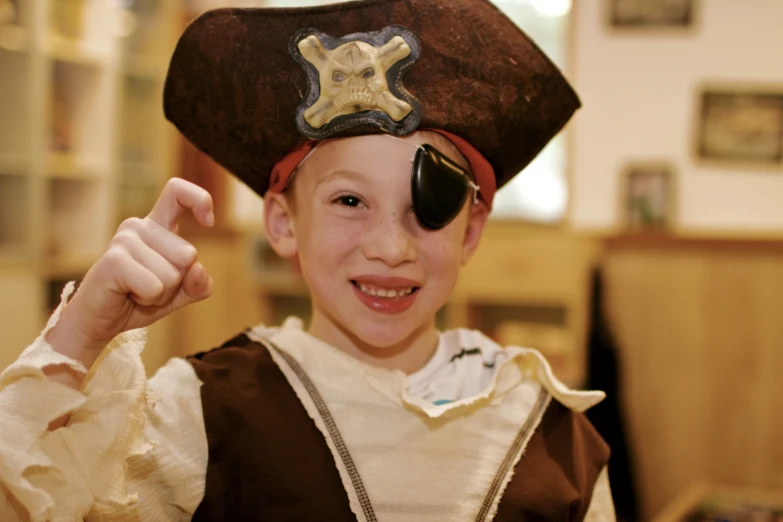 the boy wears a pirate hat and sunglasses