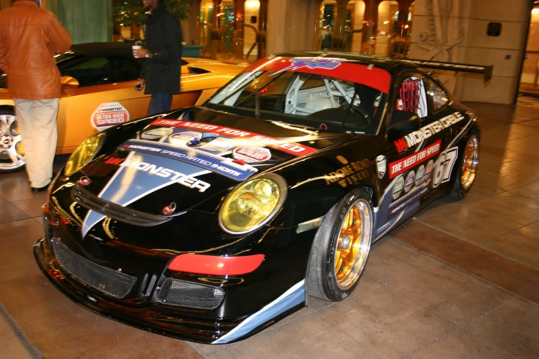 a black car sits parked on the floor and has its doors open