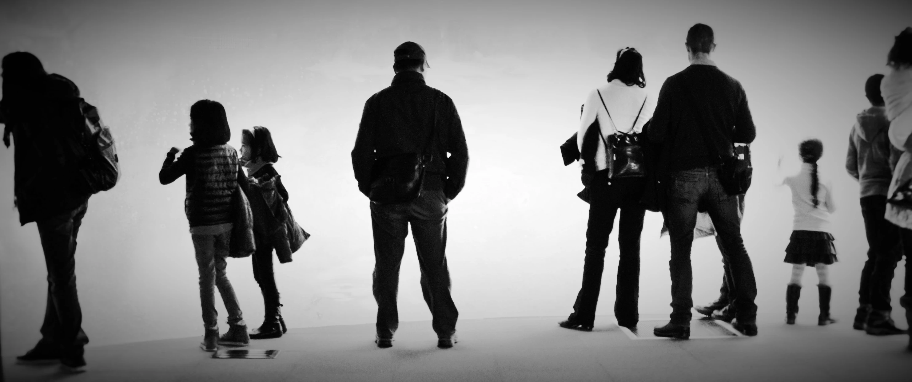 black and white pograph of people looking at a wall