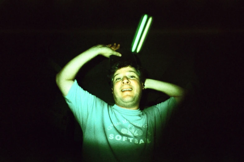 a young man holding two large lights in the dark
