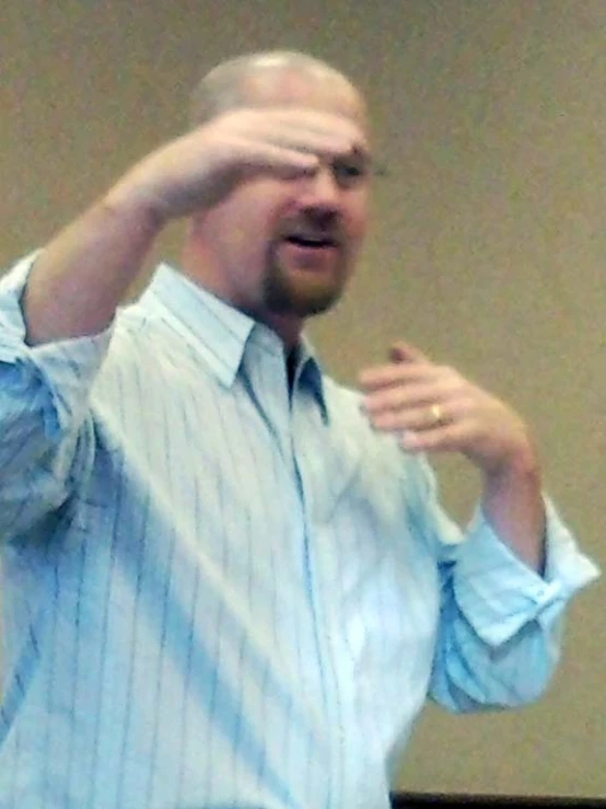 a man with glasses making a fist gesture