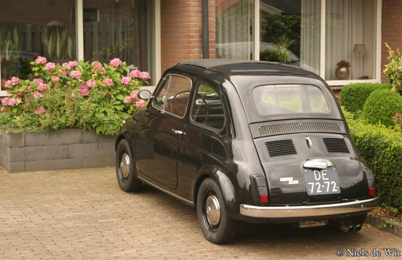 an old vintage volkswagen parked in front of a building