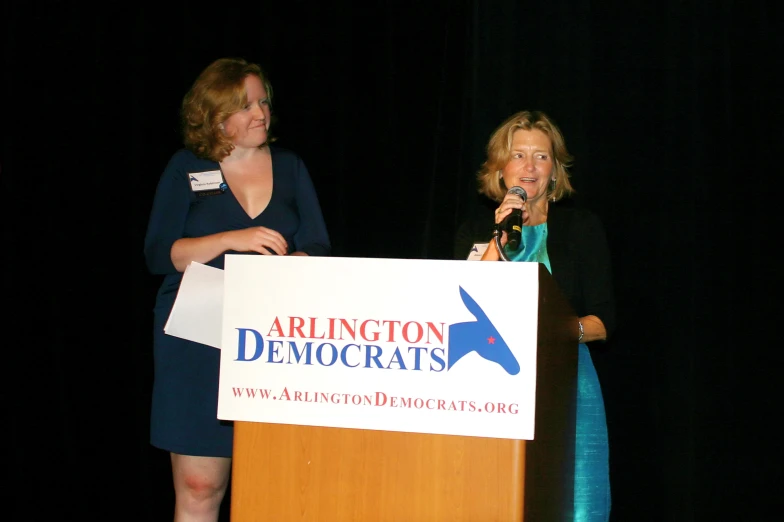 two women are speaking at an event with a microphone