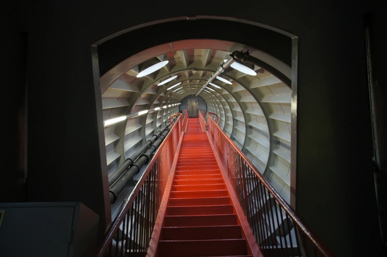 a red staircase leads down to another tunnel