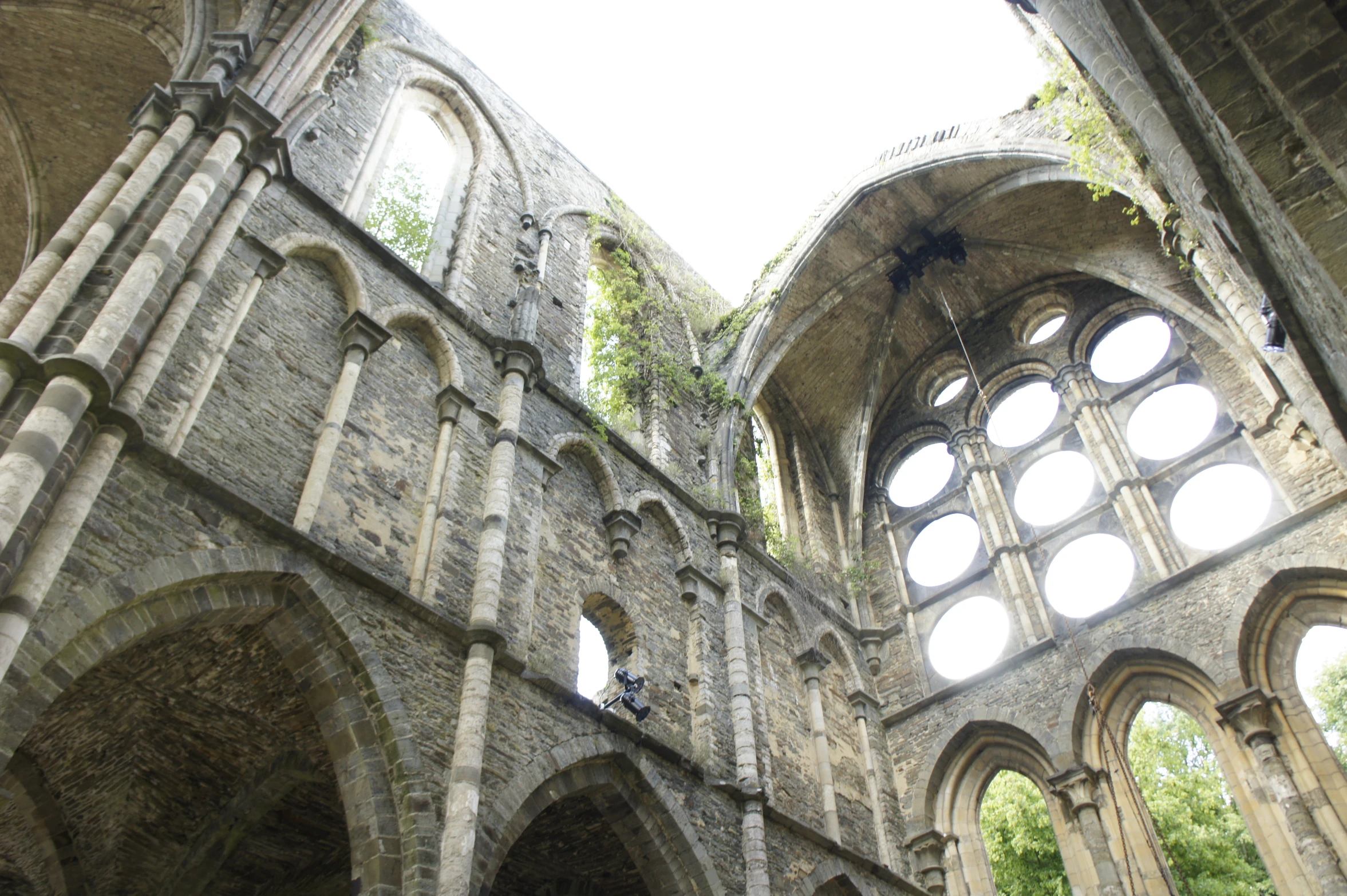 an abandoned church with windows and vines on the walls