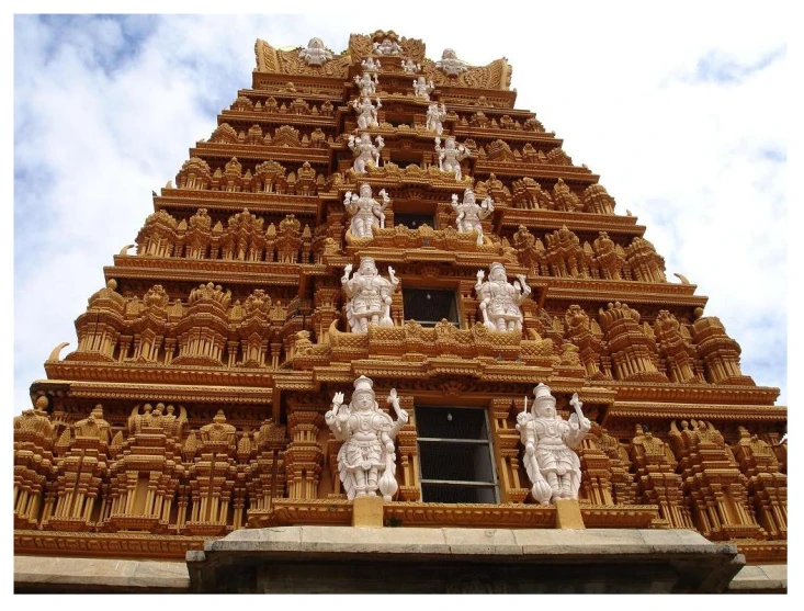 the top of an elaborate wooden building has statues on it