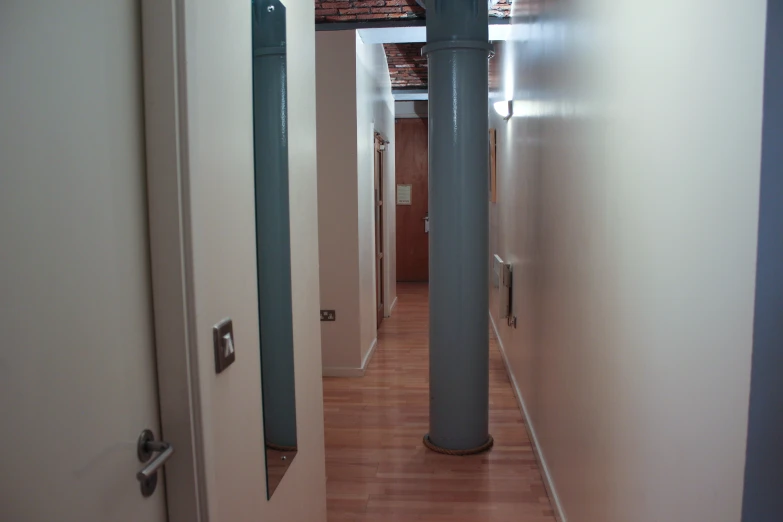 an office hallway with two metal and wood poles