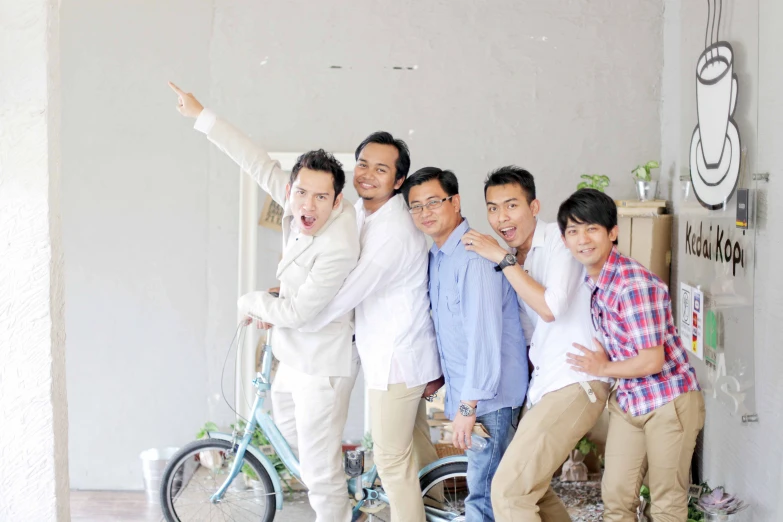 a group of people posing for the camera with a bicycle