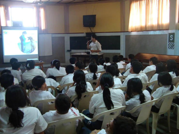 a class room filled with girls with one person speaking