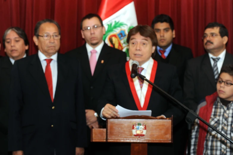 several men standing behind a man wearing a suit