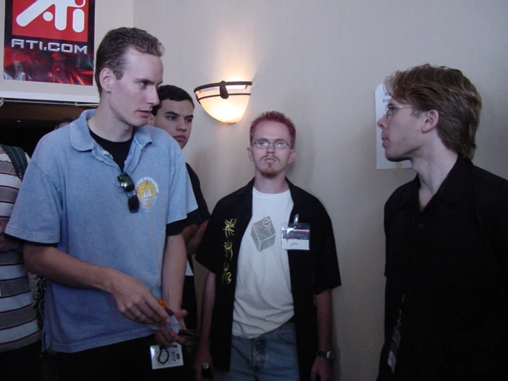 group of young men talking in room with sign in back