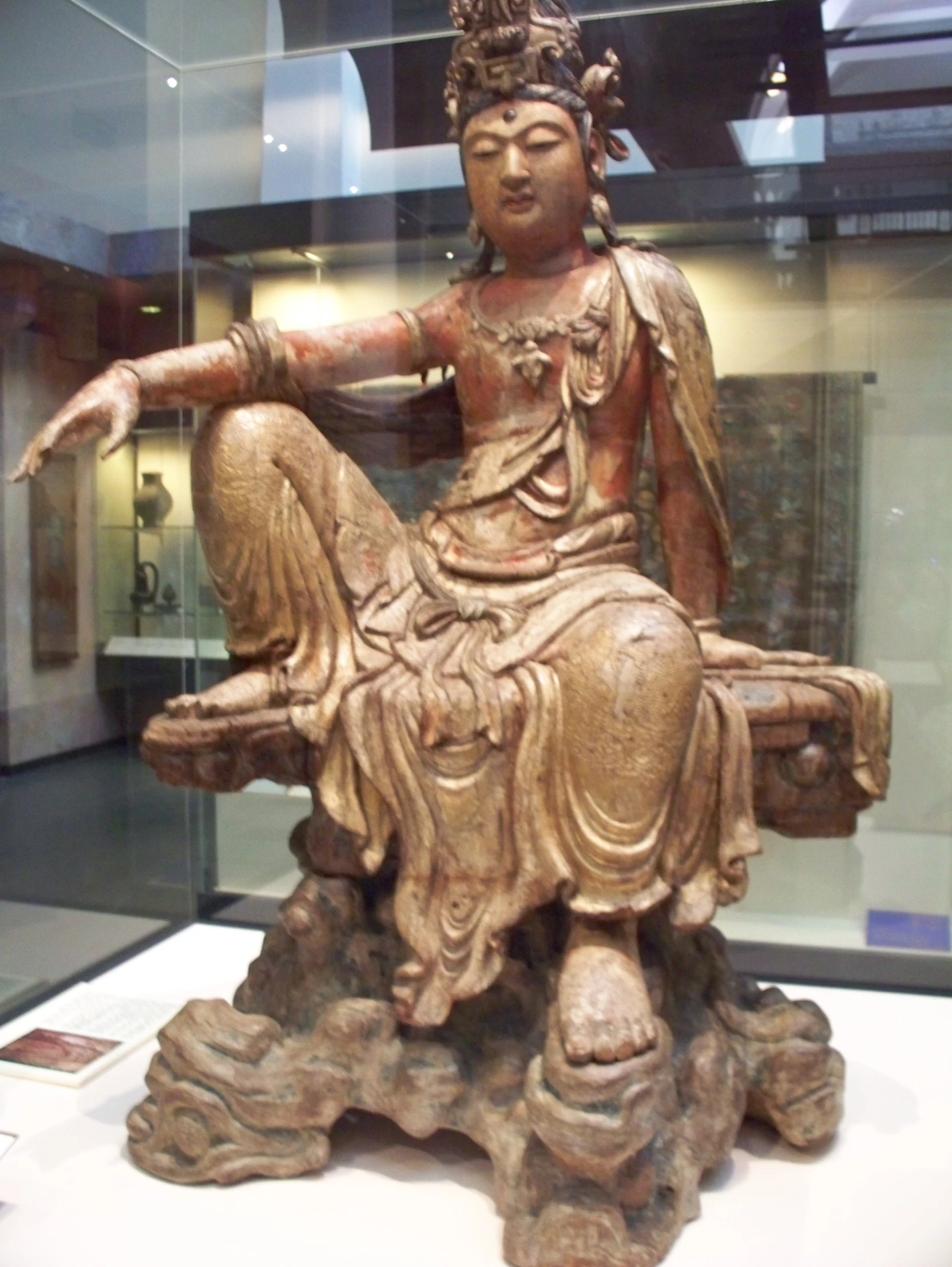 a bronze statue with a sitting woman on it