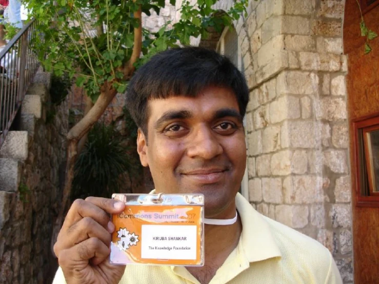 a man is holding up a label with an id