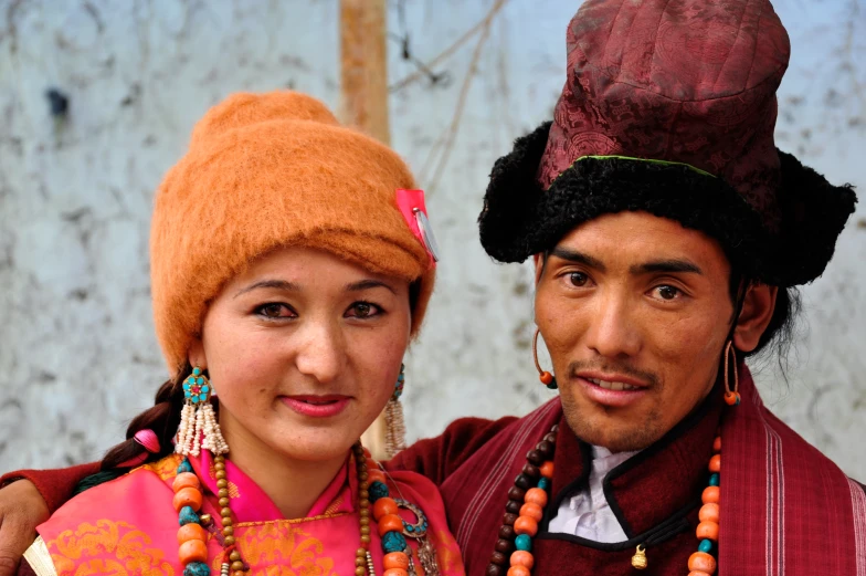 two people standing close together wearing hats