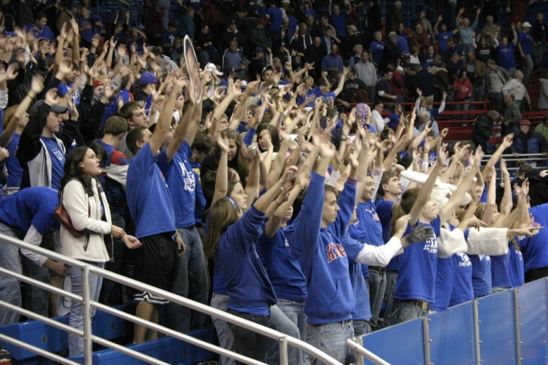 some people are sitting and clapping on the bleachers