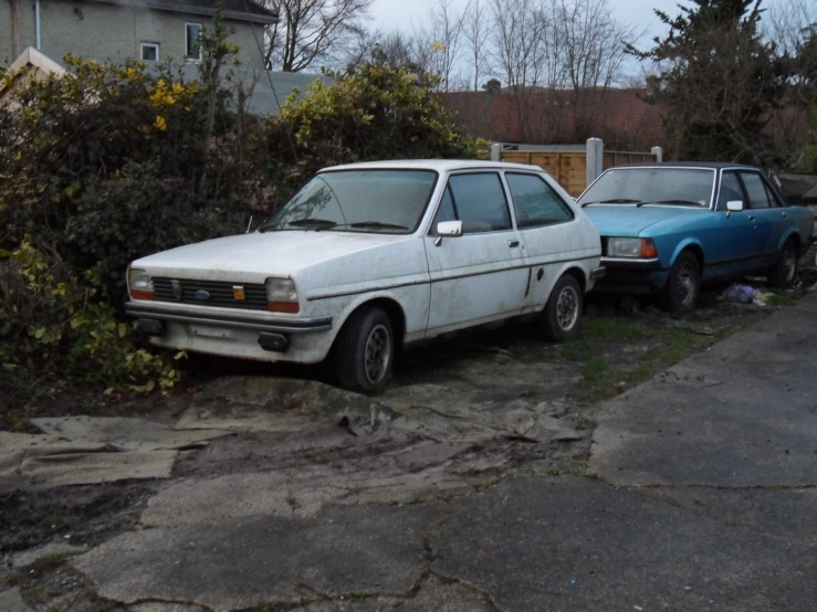 two cars parked on the side of the road with one car off to the side