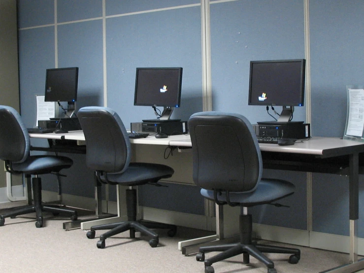 a set of four computer monitors sitting on top of a table