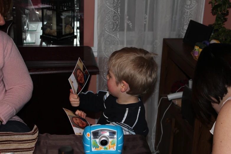 a little boy holding a book while sitting on a couch