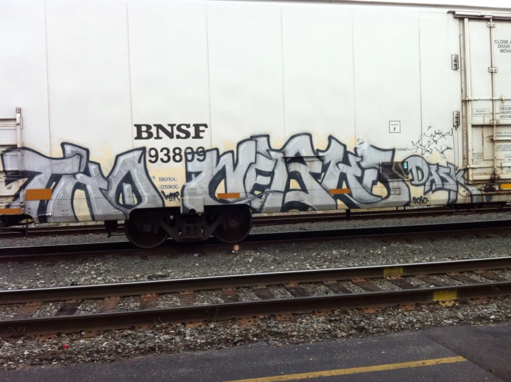 a train car covered with graffiti on the tracks