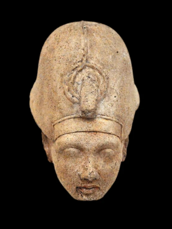 an ancient statue head of a person wearing a hat