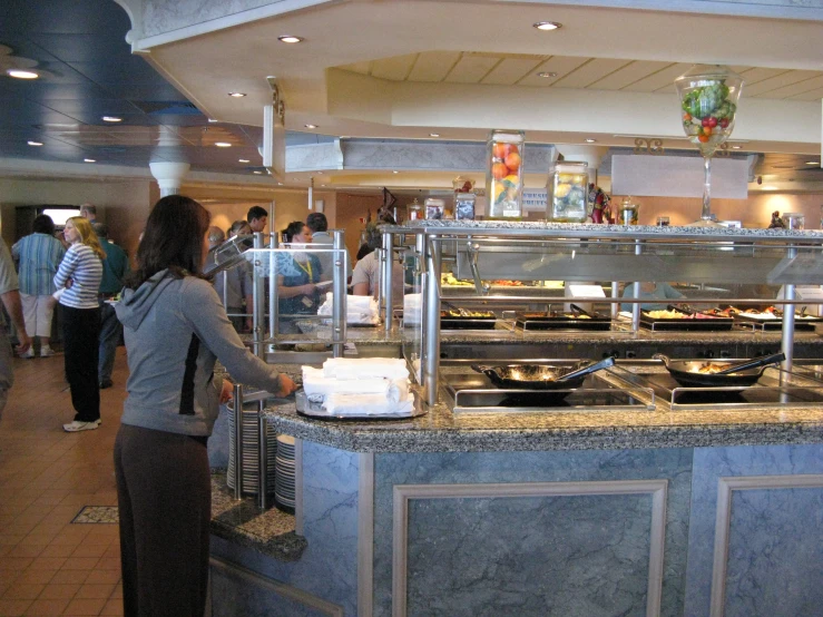 a woman is standing near some food in the kitchen