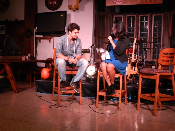 a woman sitting in a chair with a microphone behind her