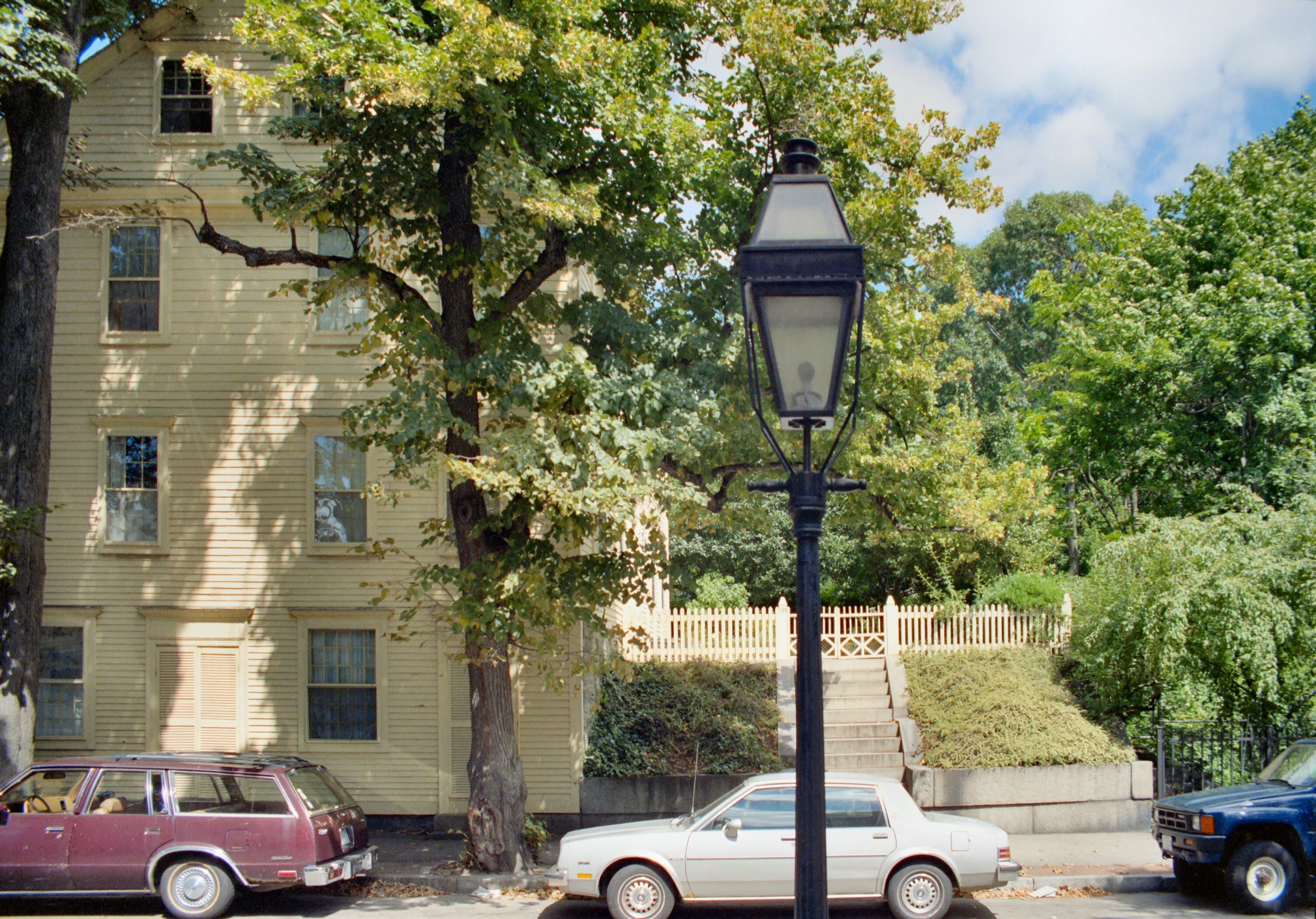 street lamp near two parked cars and a house