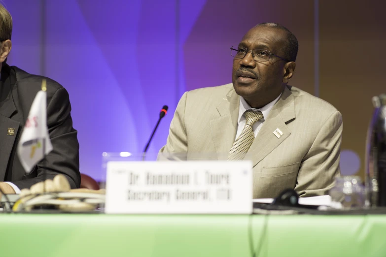 two men at a table in suits and ties