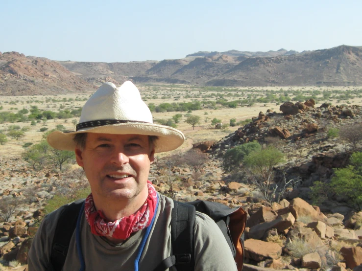 man with hat and backpack looking off into distance