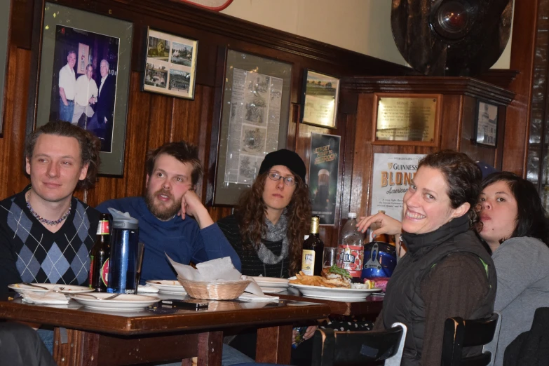 group of people sitting at a table eating dinner