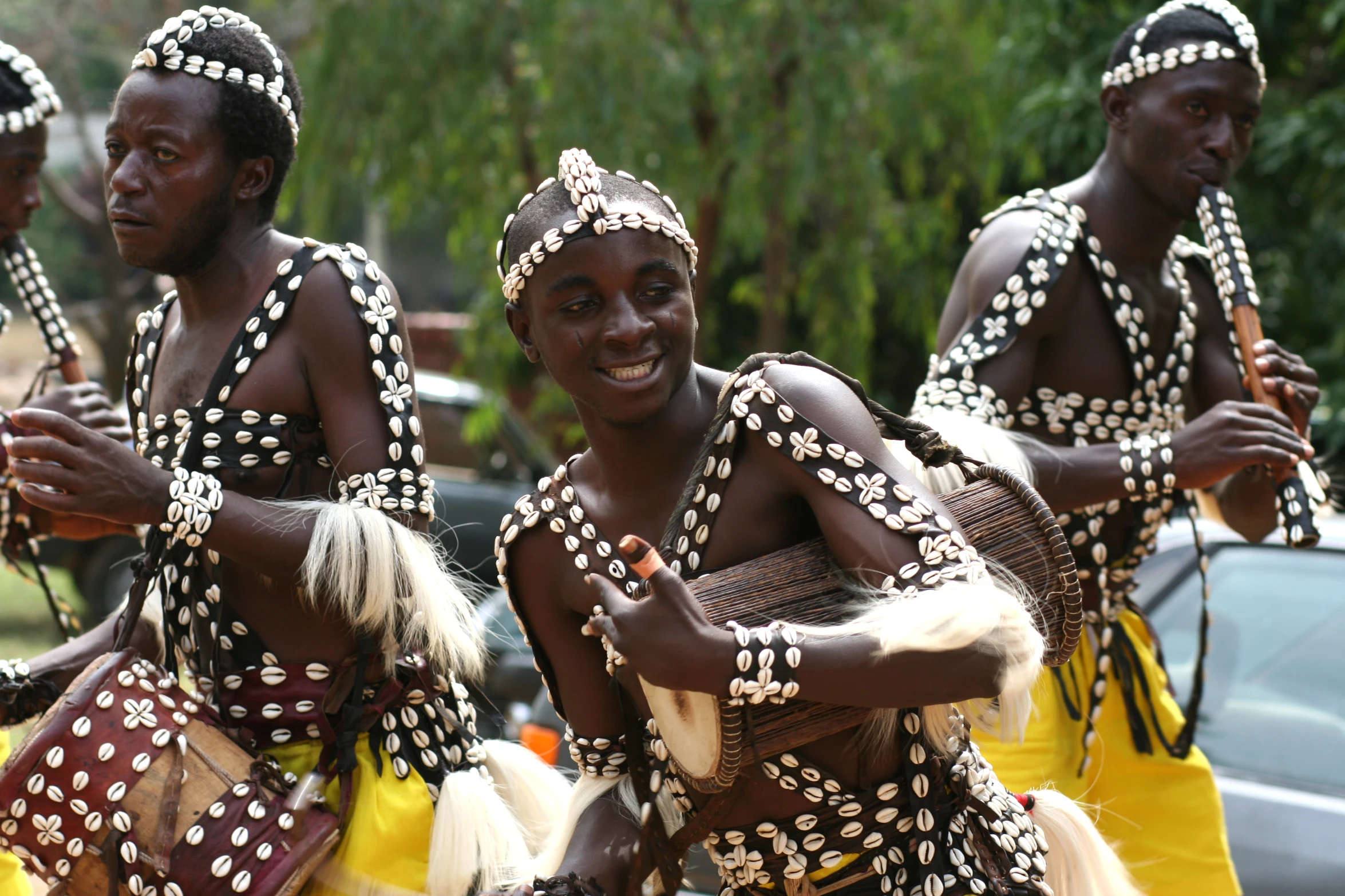 some people wearing beaded outfits and holding drums