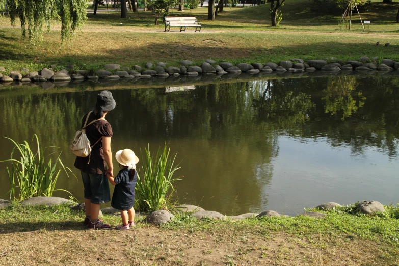 a little boy is watching his mother by the river