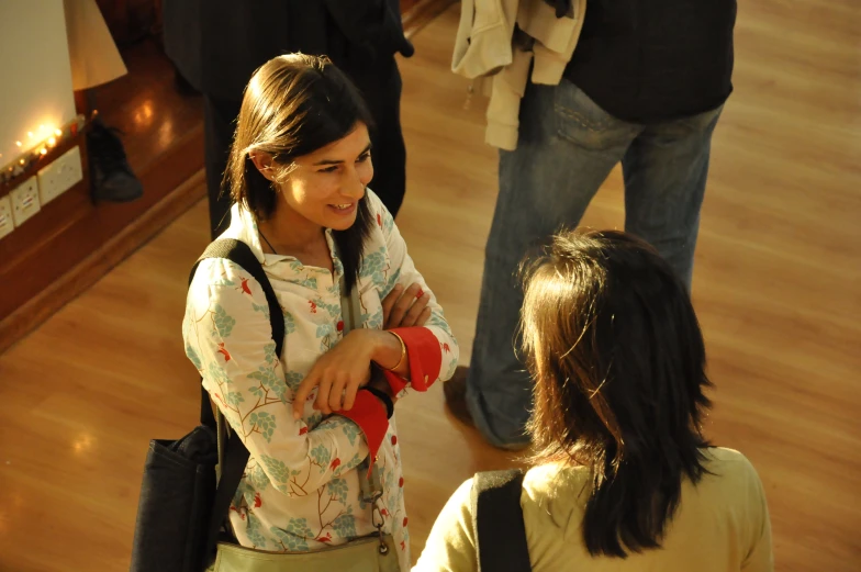 a woman is holding a cup as she talks with another woman